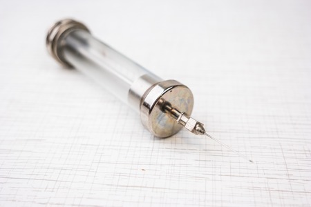 Vintage syringe on white table, medical equipmentの写真素材