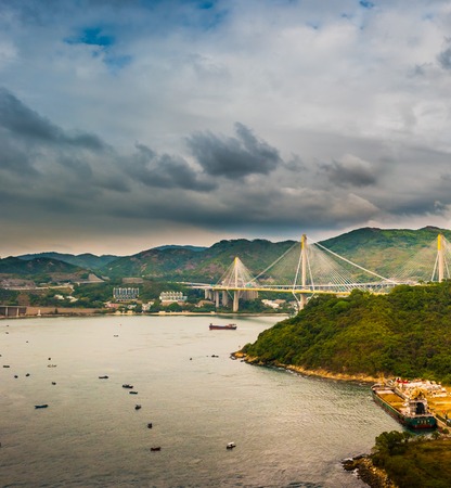 Picturesque landscape with a view on Tsing Ma Bridge, Hong Kong, China. A view with urban and industrial merging with natural mountaings on islands and gorgeous clouds.の写真素材