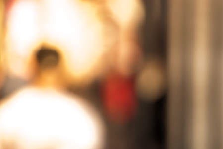 People walking down the street in the evening, beautiful light at sunset. The photo is purposely made out of focus, no faces are recognisibleの写真素材