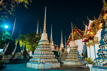 The beautifully decorated pagodas of Wat Pho temple at night. Bangkok, Thailand. Traditional religious architecture of Asia.の写真素材