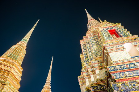 The beautifully decorated pagodas of Wat Pho temple at night. Bangkok, Thailand. Traditional religious architecture of Asia.の写真素材
