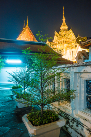 The beautifully decorated pagodas of Wat Pho temple at night. Bangkok, Thailand. Traditional religious architecture of Asia.の写真素材