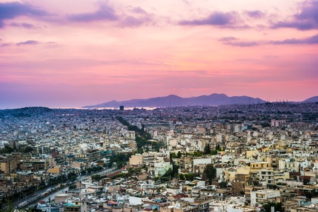 Panorama of Athens at sunset. Beautiful cityscape with seashore and distant islands visible under the red sunset sky. Travel photography.の写真素材