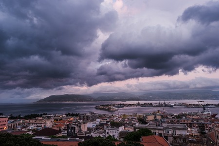 Sunset in the Port of Messina in Sicily Italy. Clouds and sunset light with night illumination.の写真素材