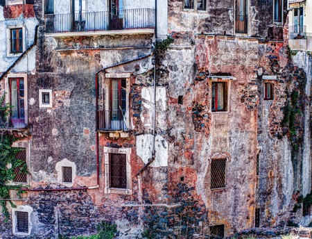 Fragment of red vintage old brick wall with windows and green ivy. Textural background.の写真素材