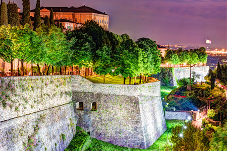 Stone walls of Castle La Rocca in Bergamo old town, Italy under the night lights.の写真素材