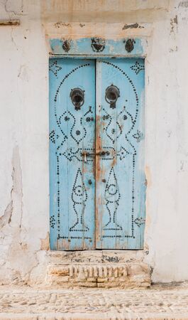 Traditional old painted door in a historical district or medina, Tunisia.の写真素材