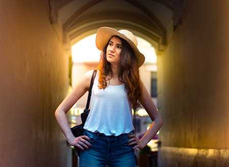 Girl with hat on summer day in the street.の写真素材