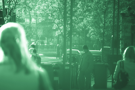 People walking down the street in the evening, beautiful light at sunset. The photo is purposely made out of focus, no faces are recognisibleの写真素材