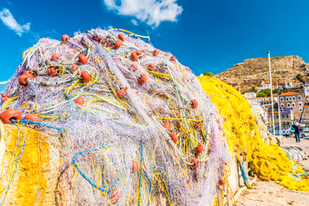 Colorful fishing nets in the harbour of a small fishing town on the coast of the Saronic island of Hydra in Aegean sea, Greeceの写真素材