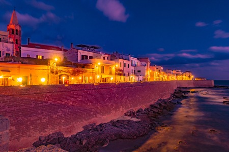 Historical center of Alghero, Sardinia, Italy. Beautiful photo of coastline fortres and houses with night illlumination.の写真素材