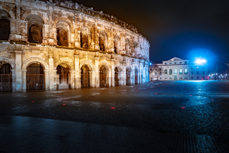 Panorama of illuminated Roman amphitheater in French city of Nimes at night. Beautiful picture of travel destination in France.の写真素材