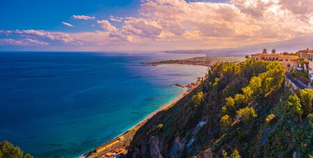 A panoramic view of Taormina, Giardini Naxos and Mount Etna, in Sicily, Italy. Photo taken from Via Teatro Greco, in Taormina.の写真素材