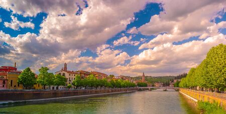 Verona, Italy. A scenic panoramic view of the river of Adige and its embankments on a cloudy and bright dayの写真素材