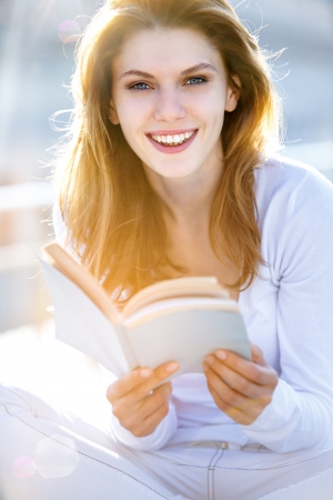 Lovely young woman holding a bookの写真素材