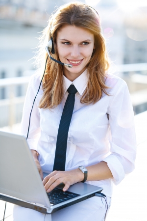 Busy call center operator works at laptopの写真素材