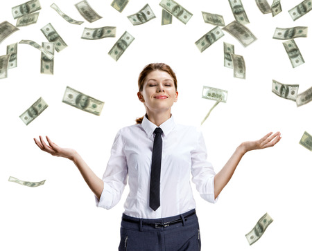 Dream of raining money - studio shoot of beautiful attractive business woman under money rain - isolated on white backgroundの写真素材