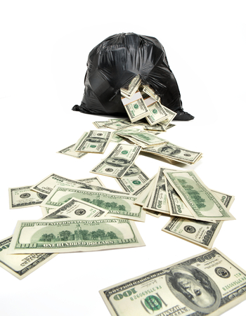 Broken bag of money - studio photography of black plastic bag with hundred dollar bills on a white backgroundの写真素材