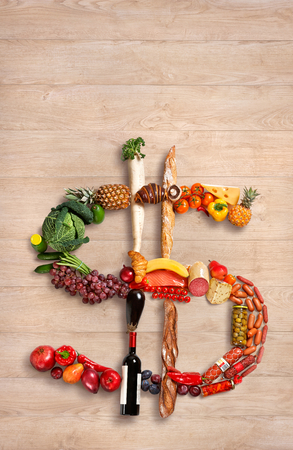photography of dollar sign made of fruits, vegetables and other products on wooden tableの写真素材