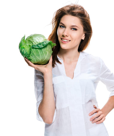 Good looking woman of European appearance holding a head of cabbage in her hand, healthy food conceptの写真素材