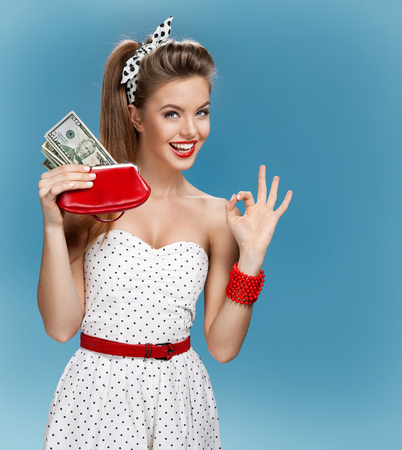Thrilled young lady holding cash and happy smiling. Shopping conceptの写真素材