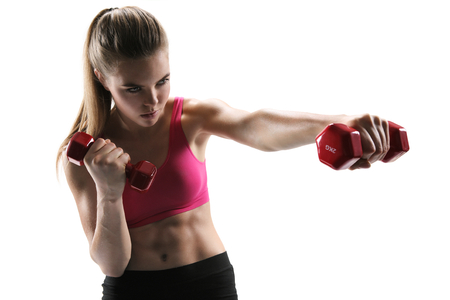 Pretty young woman doing push exercise with a dumbbell as a part of a fitness workoutの写真素材