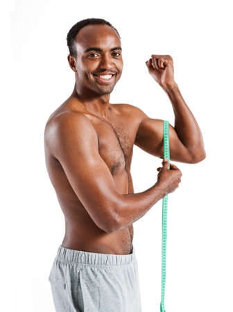 Muscular man is being measured  photo set of sporty muscular Hispanic man wearing sports clothes over white backgroundの写真素材