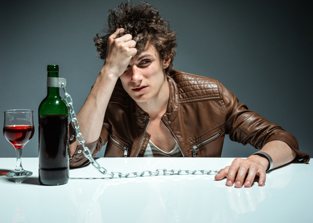 Young drunk man with a bottle of red wine  photo of youth addicted to alcohol, alcoholism concept, social problemの写真素材