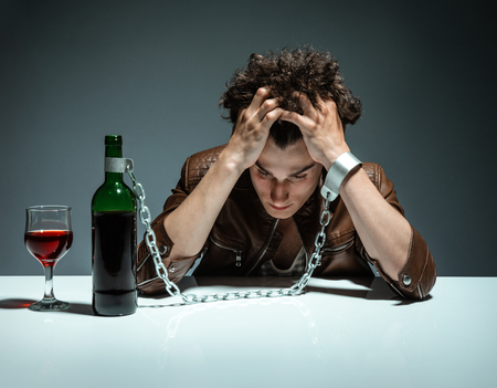 Intoxicated man sitting alone  photo of youth addicted to alcohol, alcoholism concept, social problem