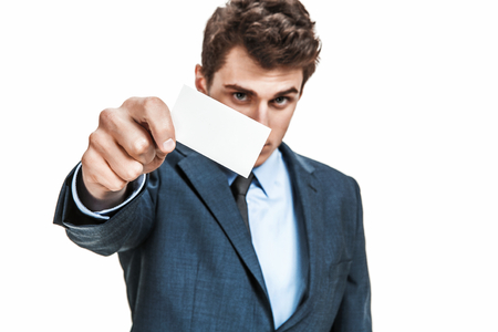 Man's hand showing business card  photos of young businessman wearing  a suit and tie over white backgroundの写真素材