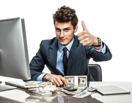 Cheerful chief showing thumbs up success sign  modern businessman at the workplace working with computerの写真素材