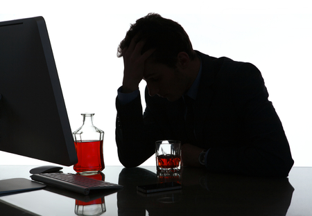 Silhouette of alcoholic drunk young man  photo of businessman addicted to alcohol at the workplace, depression and crisis concept