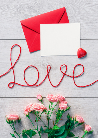 Red envelope with letter and flowers on a wooden background. Valentines Day backgroundの写真素材