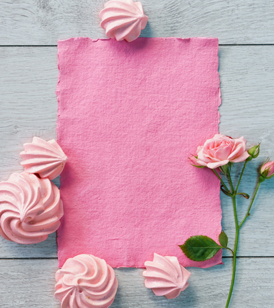 Pink paper and zephyrs for valentine's day on wooden background. View from above.の写真素材