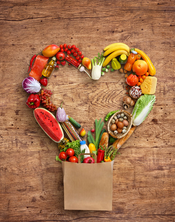 Heart symbol in package. Studio photography of heart made from different fruits and vegetables on old wooden background. Top view. High resolution product.の写真素材