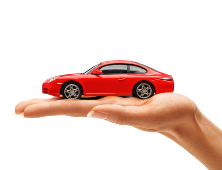Woman's hand holding a red toy car isolated on white background. Business conceptの写真素材