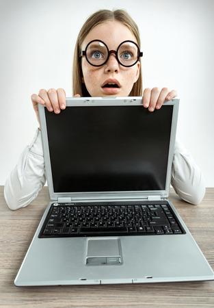 Surprised girl staring at you with her mouth open. Photo of teen girl with laptop, creative concept with Back to school themeの写真素材