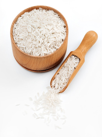 Rice in wooden bowl and spoon on white background. Close up, high resolution product.の写真素材