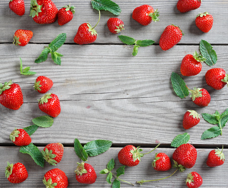 Frame from strawberry and mint leaf on wooden background. Close up, top view, high resolution product.の写真素材