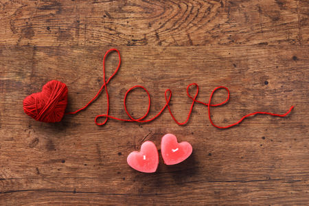 Romantic Valentine's background with candles heart shapes on wooden background. View from above. Valentines Day conceptの写真素材