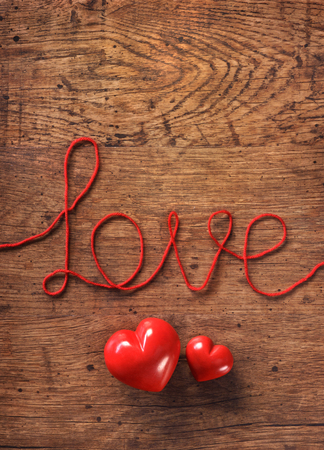 Red hearts and word "love" on wooden table. Copy space for your text. Top view. Valentines Day conceptの写真素材