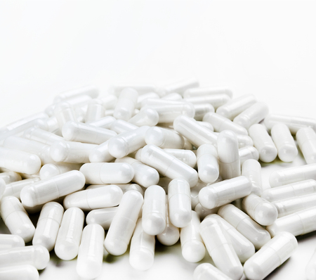 Pile of white capsules on white background. Close up, high resolution product. Health care conceptの写真素材