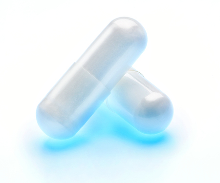 Two glowing capsules, isolated on white background. Close up, high resolution product. Health care conceptの写真素材