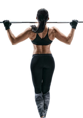 Exercise for the back. Photo of a strong attractive woman doing pull-ups on a white background. Back view.の写真素材