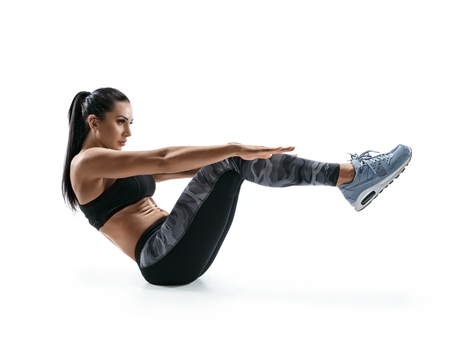 Beautiful young woman doing fitness exercise. Photo of muscular woman in silhouette on white background. Fitness and healthy lifestyle conceptの写真素材