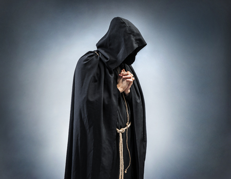 Silhouette of a praying monk, folded hands in prayer. Photo of monk at prayer. Concept for faith, spirituality and religionの写真素材