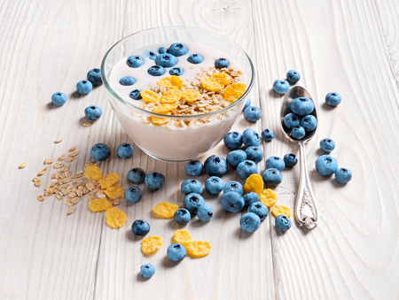 Bowl of homemade yogurt with muesli and fresh blueberry on wooden table. Fresh yogurt. Healthy food concept. High resolution product.の写真素材