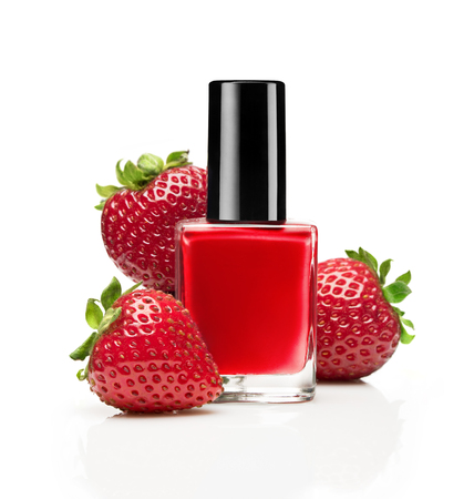 Red nail polish bottle with strawberry on white backgroundの写真素材