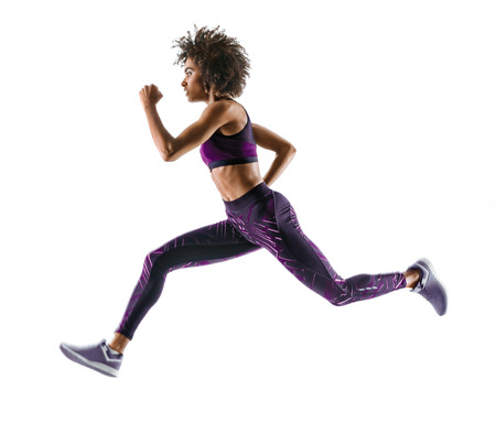 Young african girl running in silhouette on white background. Dynamic movement. Side viewの写真素材
