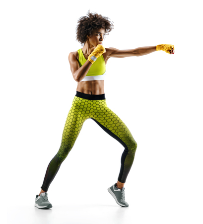 Sporty woman during boxing exercise making direct hit. Photo of boxer on white background. Strength and motivationの写真素材